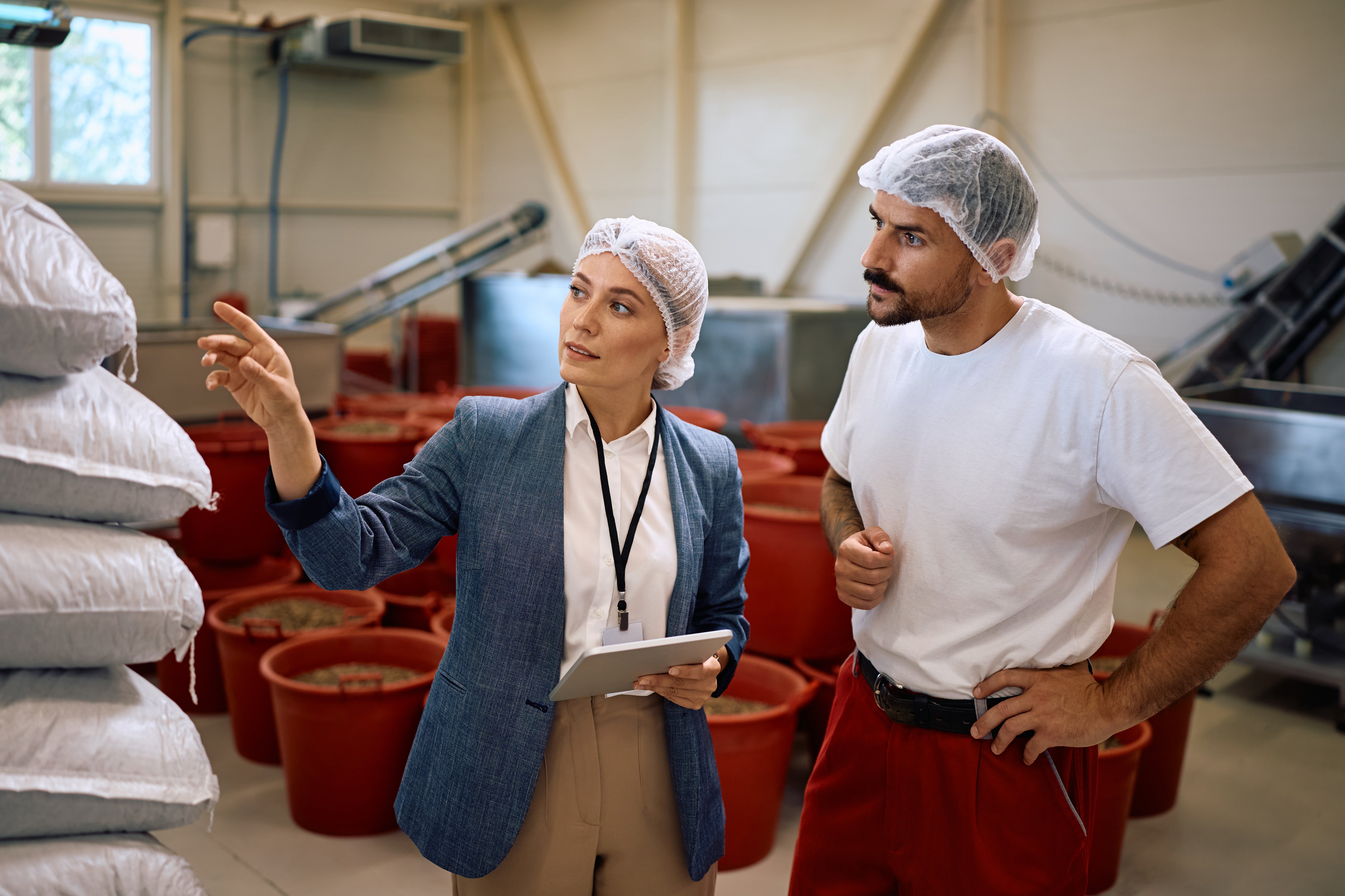 Food Factory Manager and Worker Examining Stock of Goods in Storage Room